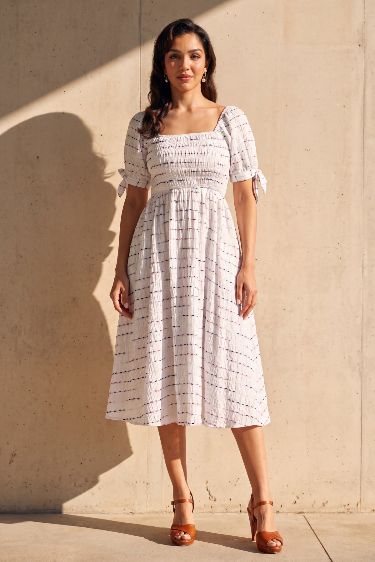 Rowan white smocked square neck midi dress, worn full length against a sunlit concrete wall
