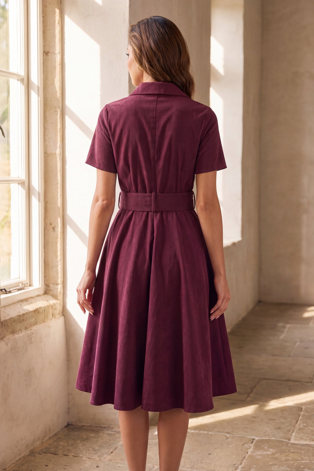 Wren burgundy corduroy shirt dress, back view beside a tall window