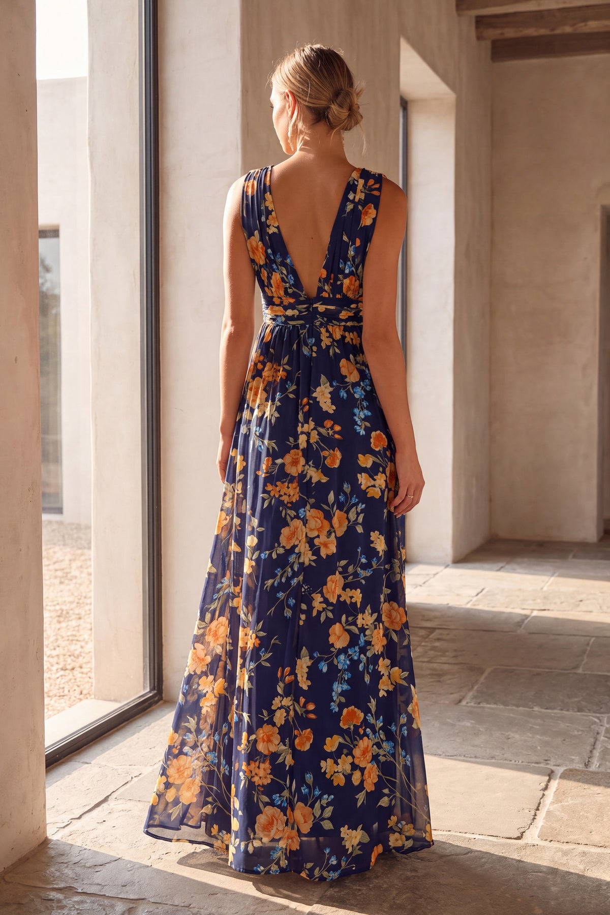 Delphine navy floral chiffon maxi dress, back view beside a tall window