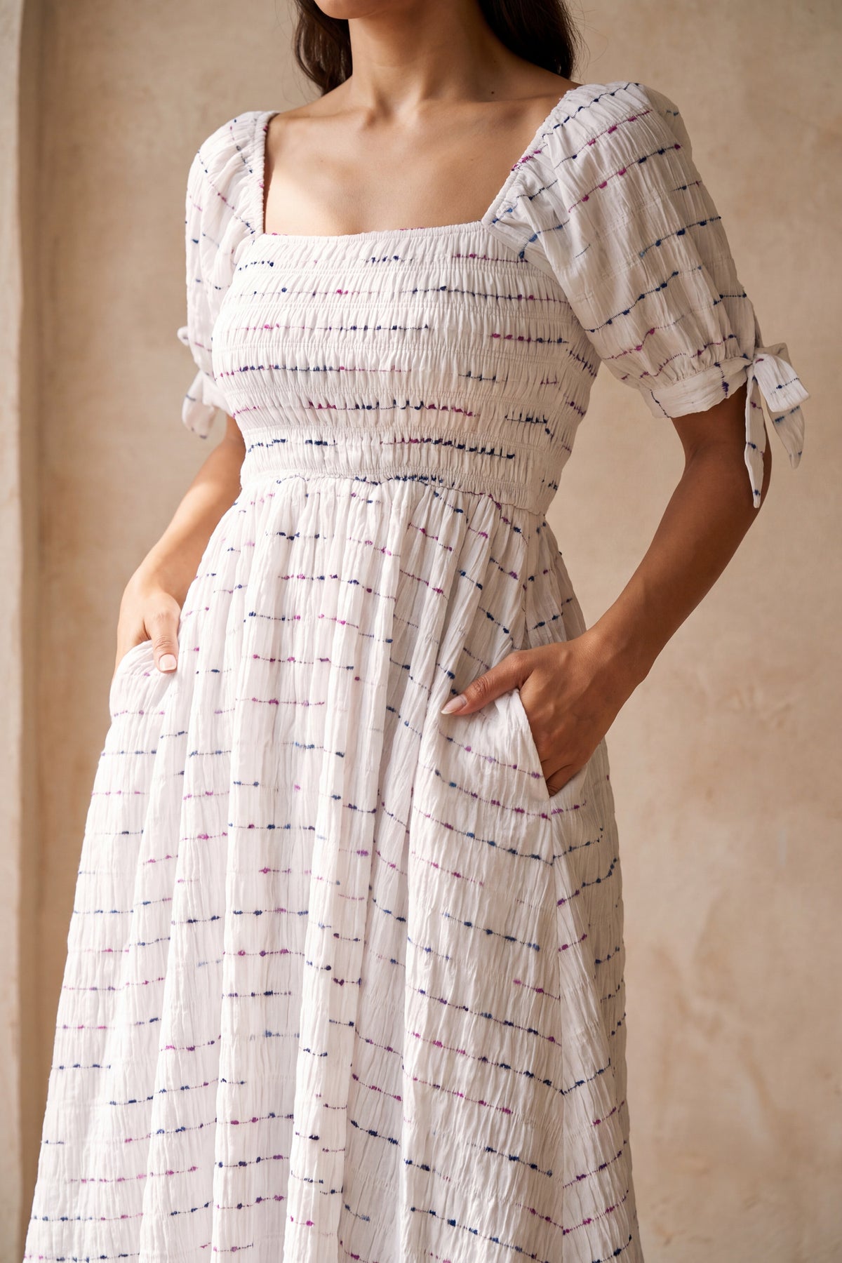 Rowan white smocked square neck midi dress, close up of neckline, bodice and fabric detail